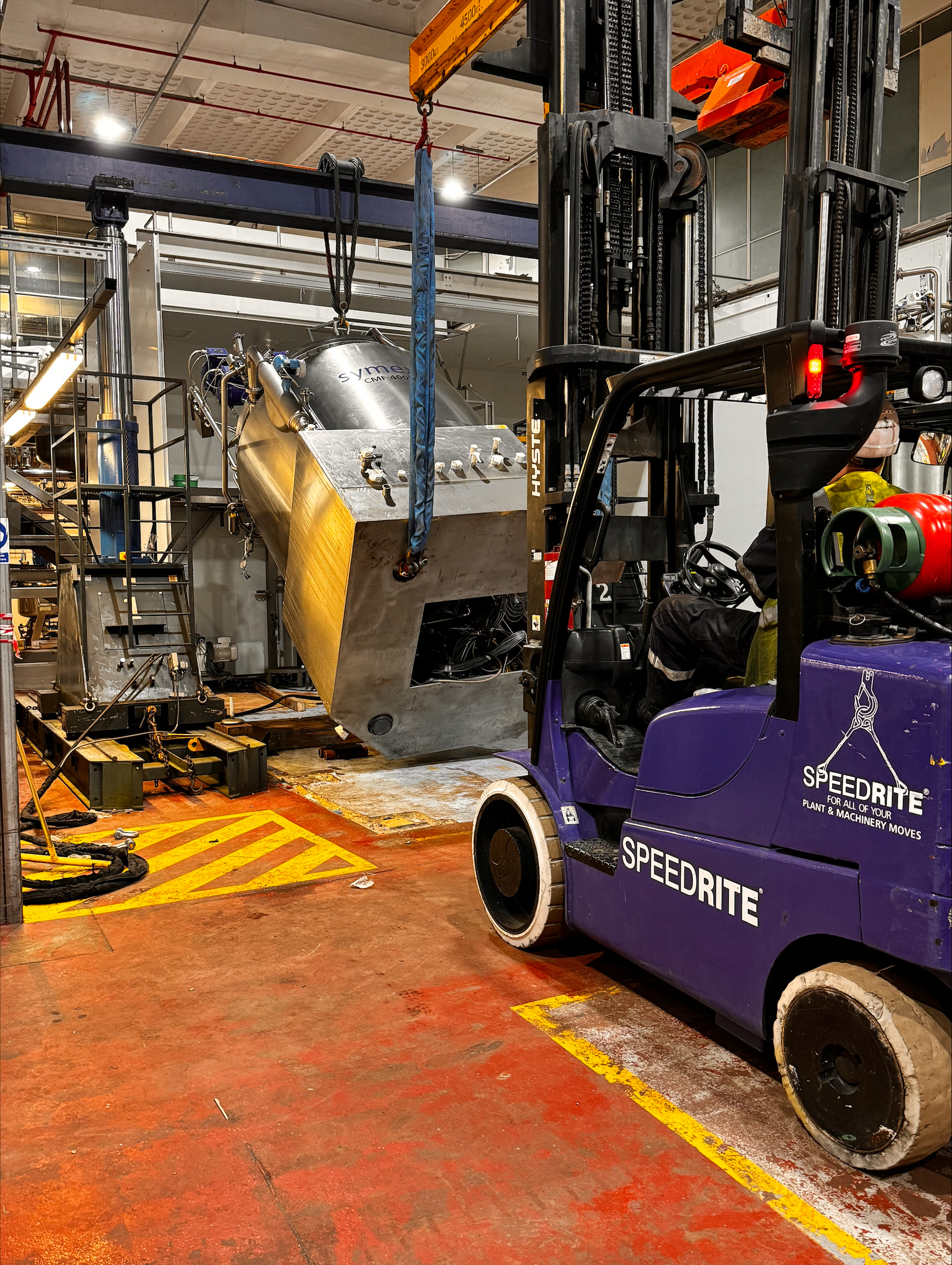 Speedrite forklift lifts machine our of a factory with a hydraulic liftsystem.