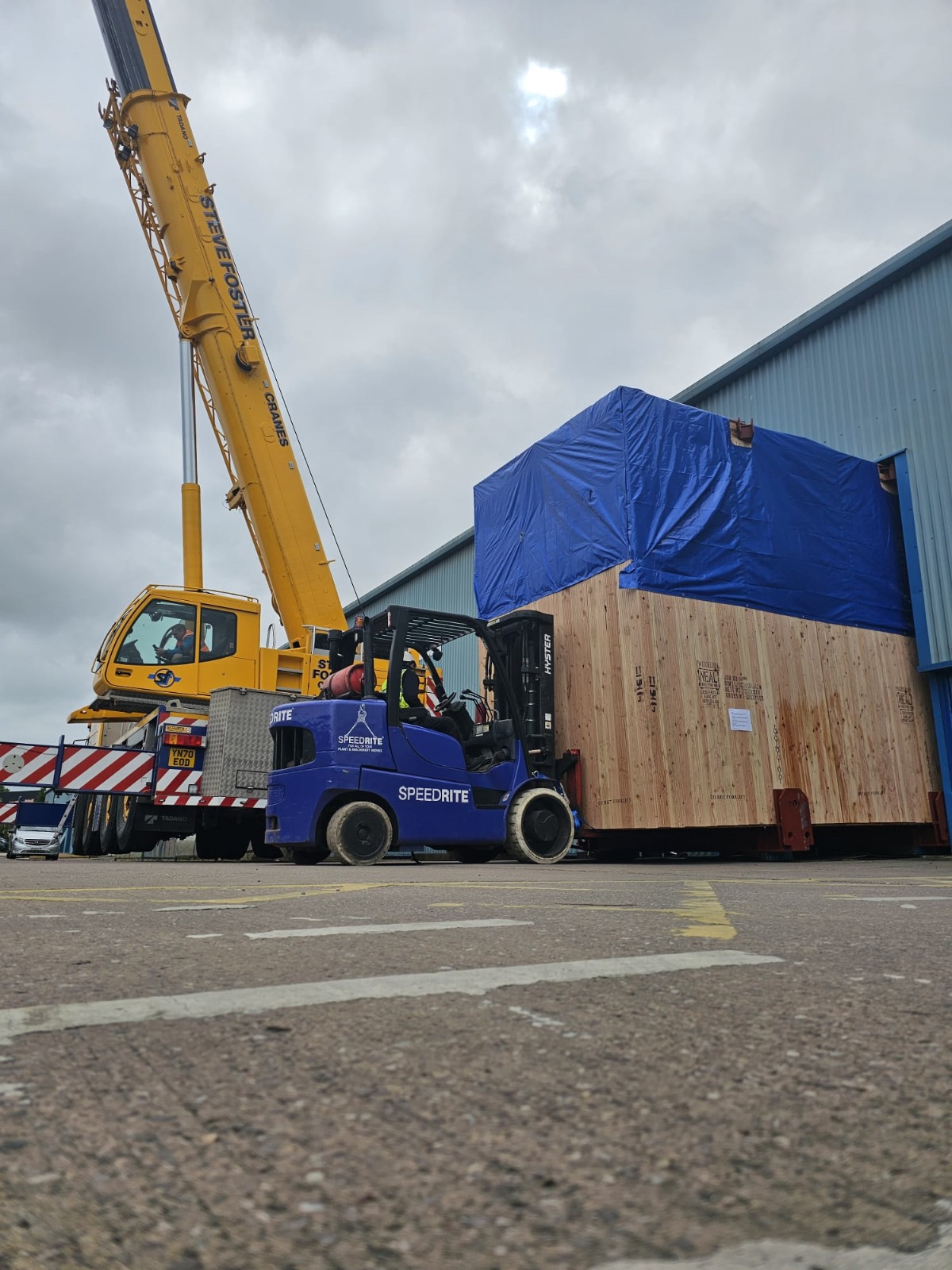 Custom crate lifted out of building by Speedrite forklift.